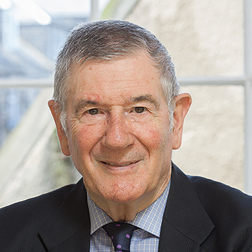 A head and shoulders picture of Iain Leslie Shaw Balfour, sitting in front of a window with a view across rooftops